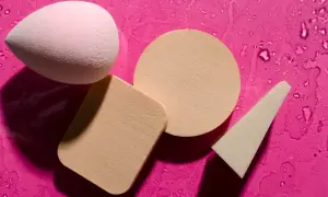 Różowy i beżowy beauty blender oraz gąbeczki na mokrym, fuksjowym tle. Dowiedz się, jak wyczyścić beauty blender, by służył Ci dłużej.