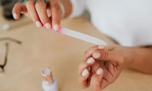 Dłonie z paznokciami w naturalnym kolorze, piłowane szklanym pilniczkiem. Poznaj różne **kształty paznokci jak piłować**.