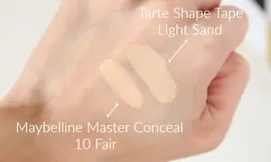 Dwa odcienie korektorów na dłoni: Tarte Shape Tape Light Sand i Maybelline Master Conceal 10 Fair.