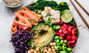 Kolorowa miska pełna warzyw: marchewka, awokado, czerwona kapusta, papryka, edamame, ciecierzyca i szpinak. To idealny posiłek dla nawilżenie skóry od środka.