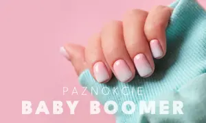 Dłoń z paznokciami w stylu ombre baby boomer. Delikatne przejście od różu do bieli, idealne na każdą okazję.