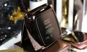 Czarne, błyszczące opakowanie pudru Hourglass Ambient Lighting Powder Dim Light.