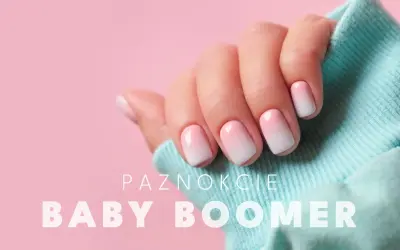 Dłoń z paznokciami w stylu ombre baby boomer. Delikatne przejście od różu do bieli, idealne na każdą okazję.