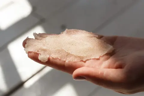 Delikatny peeling z cukru w dłoni, gotowy do odświeżenia skóry.