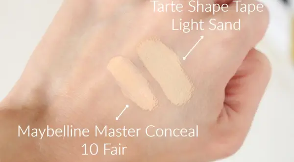 Dwa odcienie korektorów na dłoni: Tarte Shape Tape Light Sand i Maybelline Master Conceal 10 Fair.