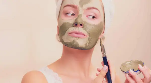 Kobieta z glinkową maską na twarzy, zastanawia się, czy to humektant co to.
