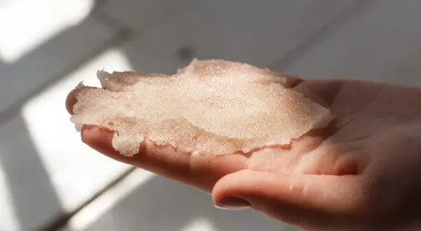 Delikatny peeling z cukru w dłoni, gotowy do odświeżenia skóry.