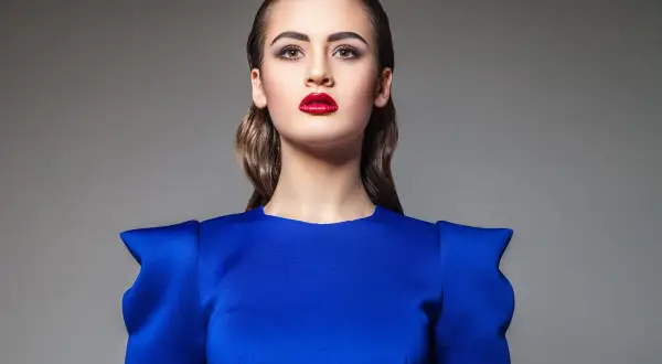 Elegancki makijaż do granatowej sukienki: mocno podkreślone usta i oczy.