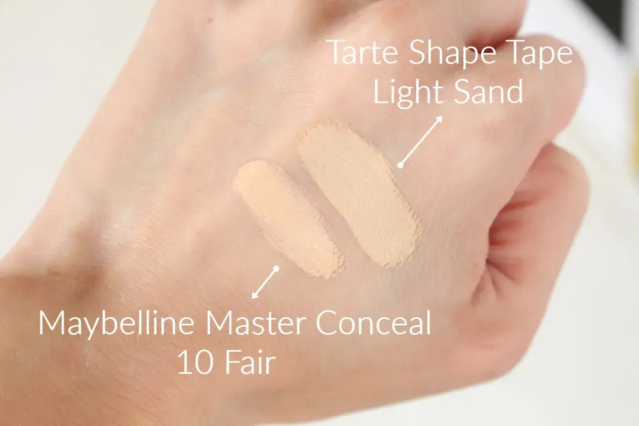 Dwa odcienie korektorów na dłoni: Tarte Shape Tape Light Sand i Maybelline Master Conceal 10 Fair.