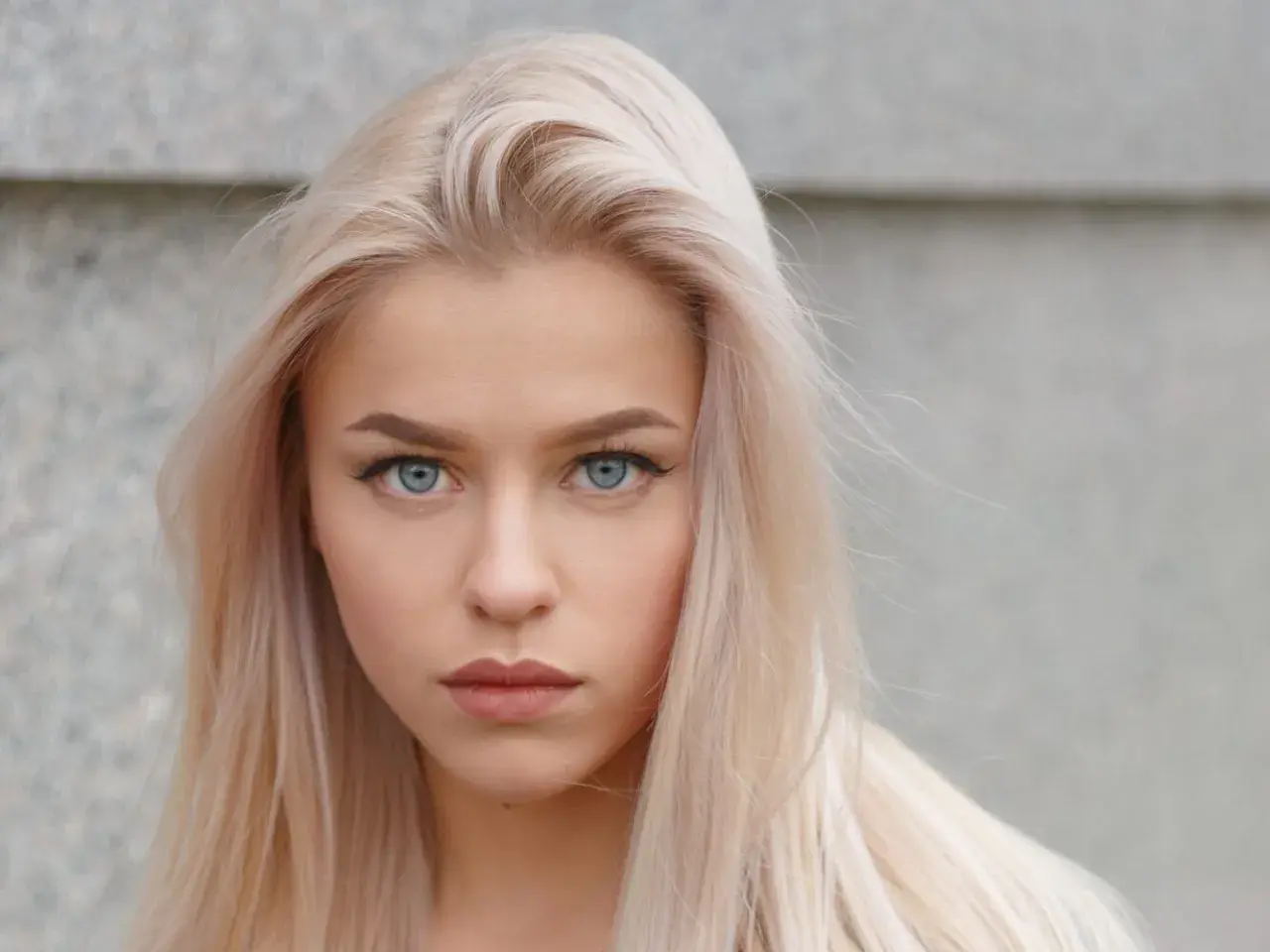 Blondynka o niebieskich oczach, z delikatnym makijażem ust. Idealne kolory szminek dla blondynek o niebieskich oczach podkreślą jej urodę.
