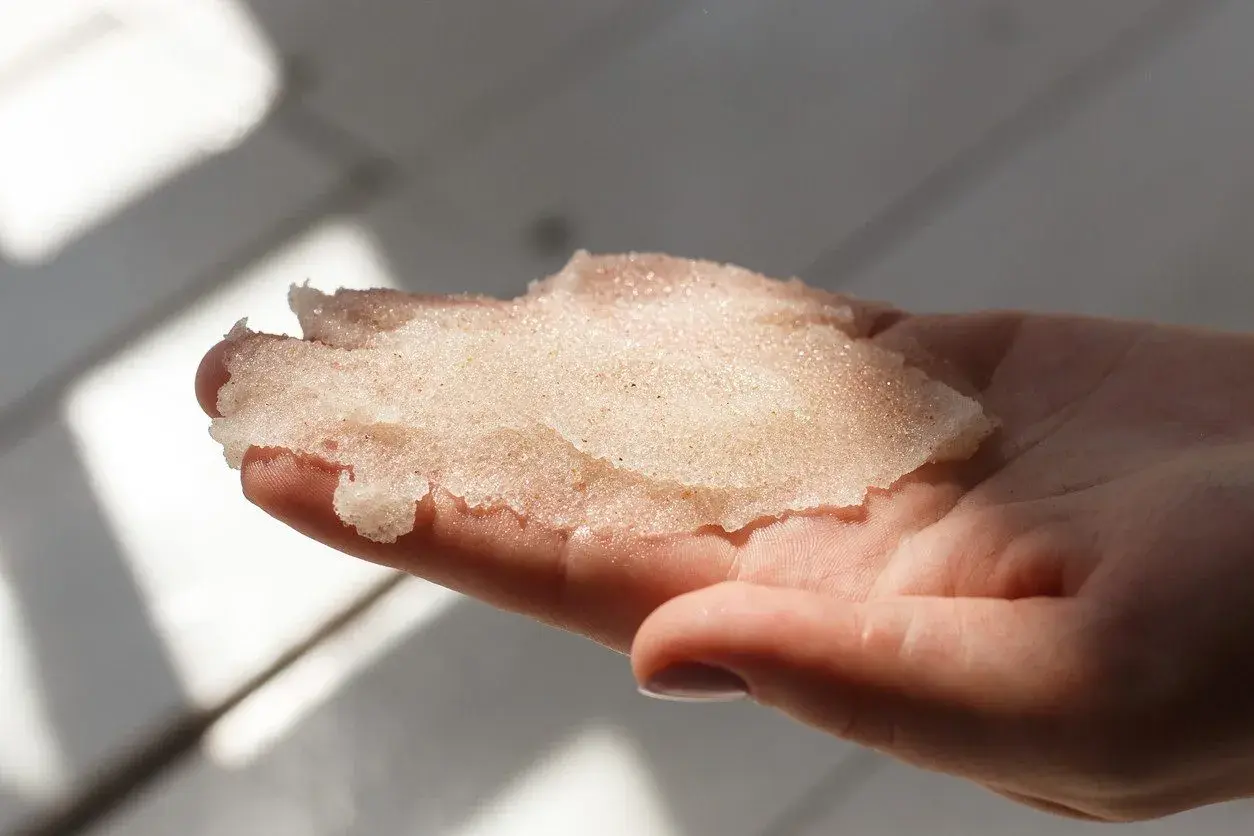 Delikatny peeling z cukru w dłoni, gotowy do odświeżenia skóry.