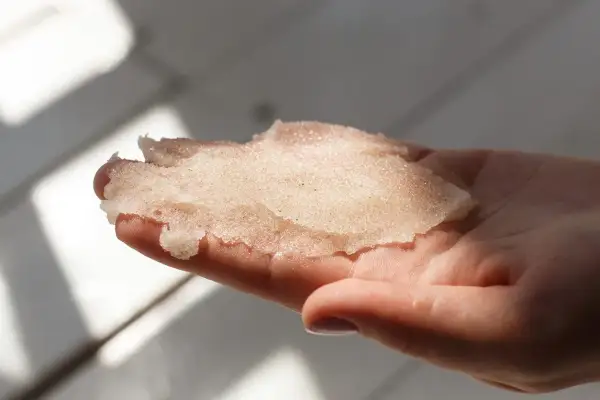 Delikatny peeling z cukru w dłoni, gotowy do odświeżenia skóry.