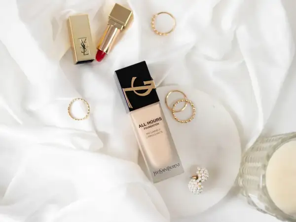 YSL All Hours Foundation – jak dobrać odcień? Złote pierścionki i szminka dopełniają luksusową kompozycję.